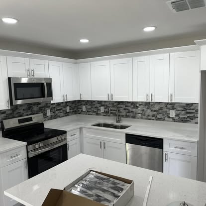 Kitchen remodel with white shaker cabinets, quartz countertops, and a mosaic tile backsplash