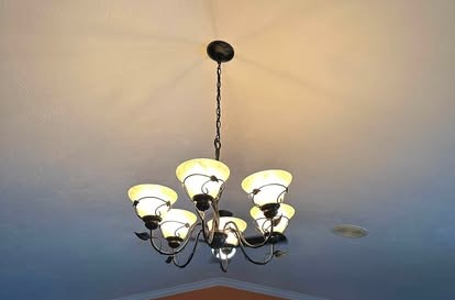 Chandelier installed in a living room with a vaulted ceiling